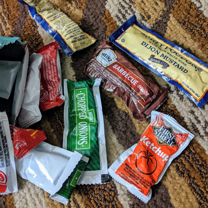 Condiment packets, spilled out on the floor. Click for full size.